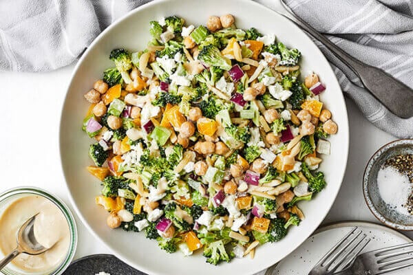 Chopped broccoli and chickpea salad next to forks