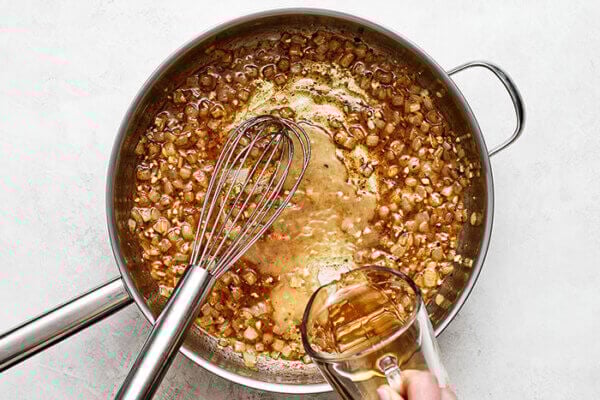 Whisking German potato salad sauce in pan