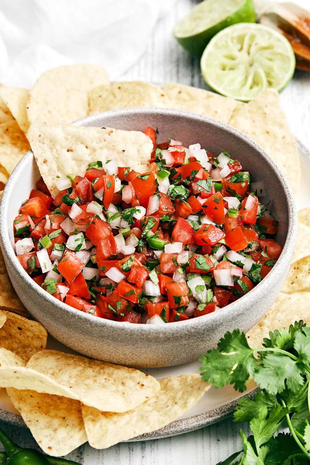 Pico de gallo is an authentic Mexican salsa that should always be served fresh and is super easy to make. Serve as a party dip or top it on tacos and more! A bowl of pico de gallo salsa.
