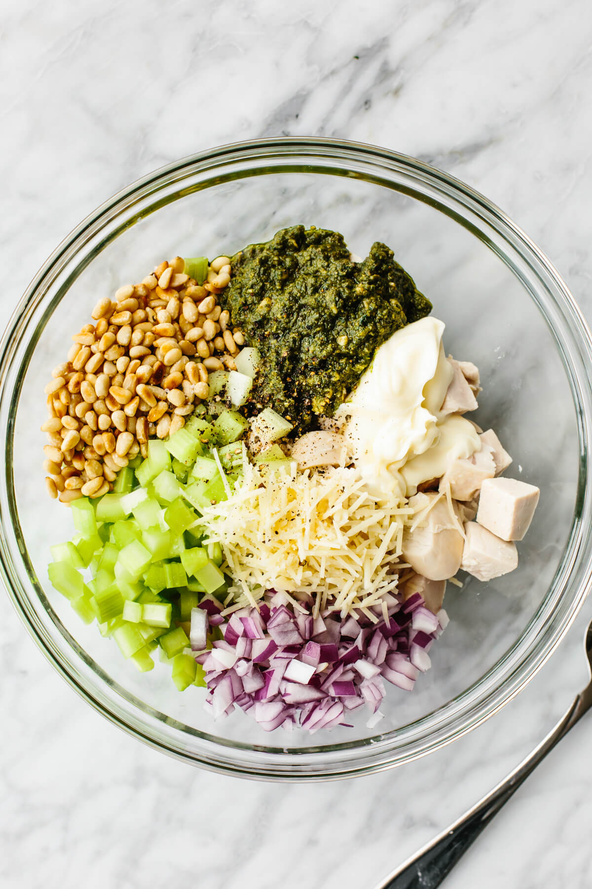 This pesto chicken salad is a fresh basil pesto spin on a classic that will undoubtedly be the summer salad of the season! Pesto chicken salad ingredients in a bowl