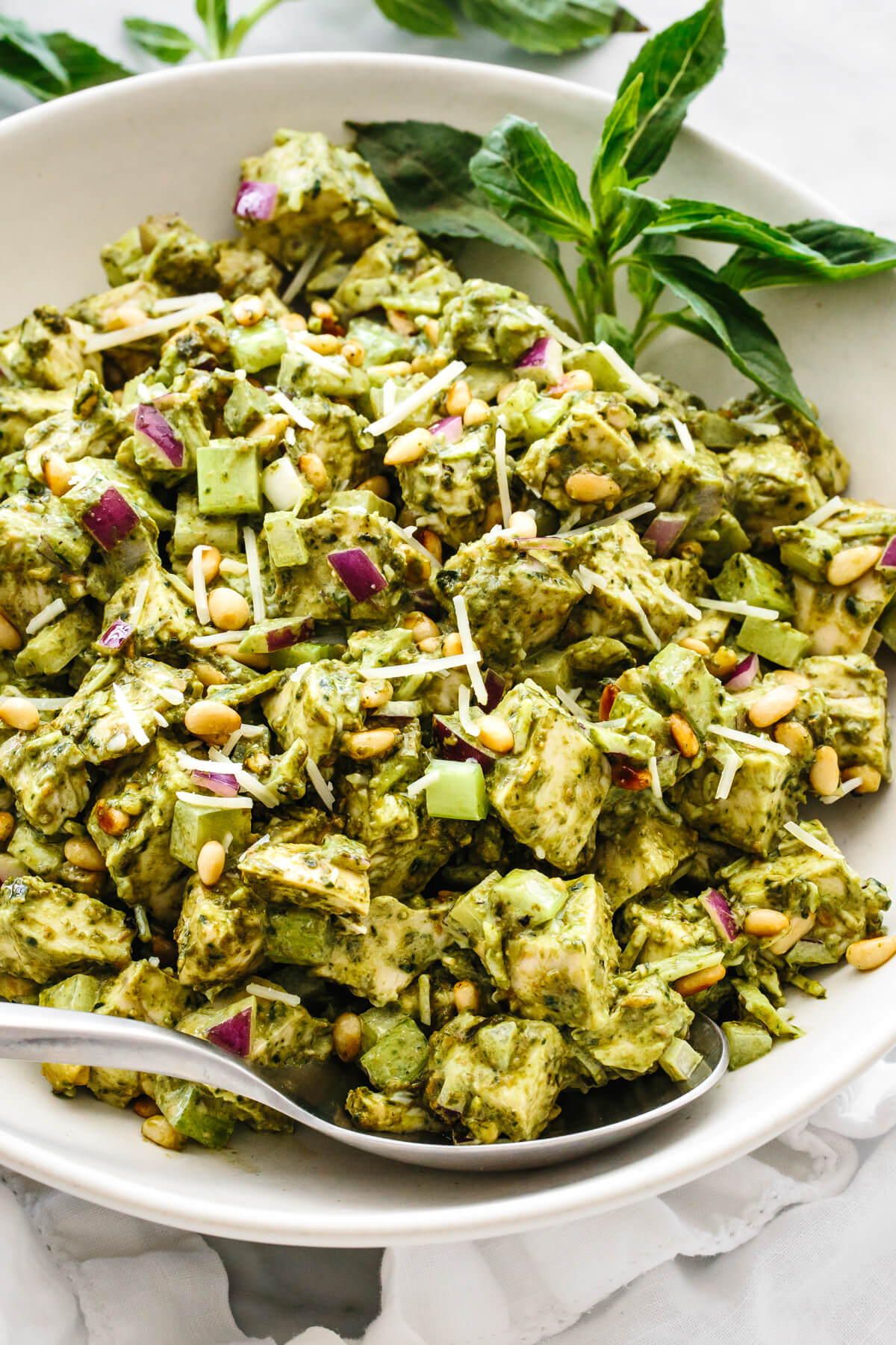 This pesto chicken salad is a fresh basil pesto spin on a classic that will undoubtedly be the summer salad of the season! A close up of pesto chicken salad