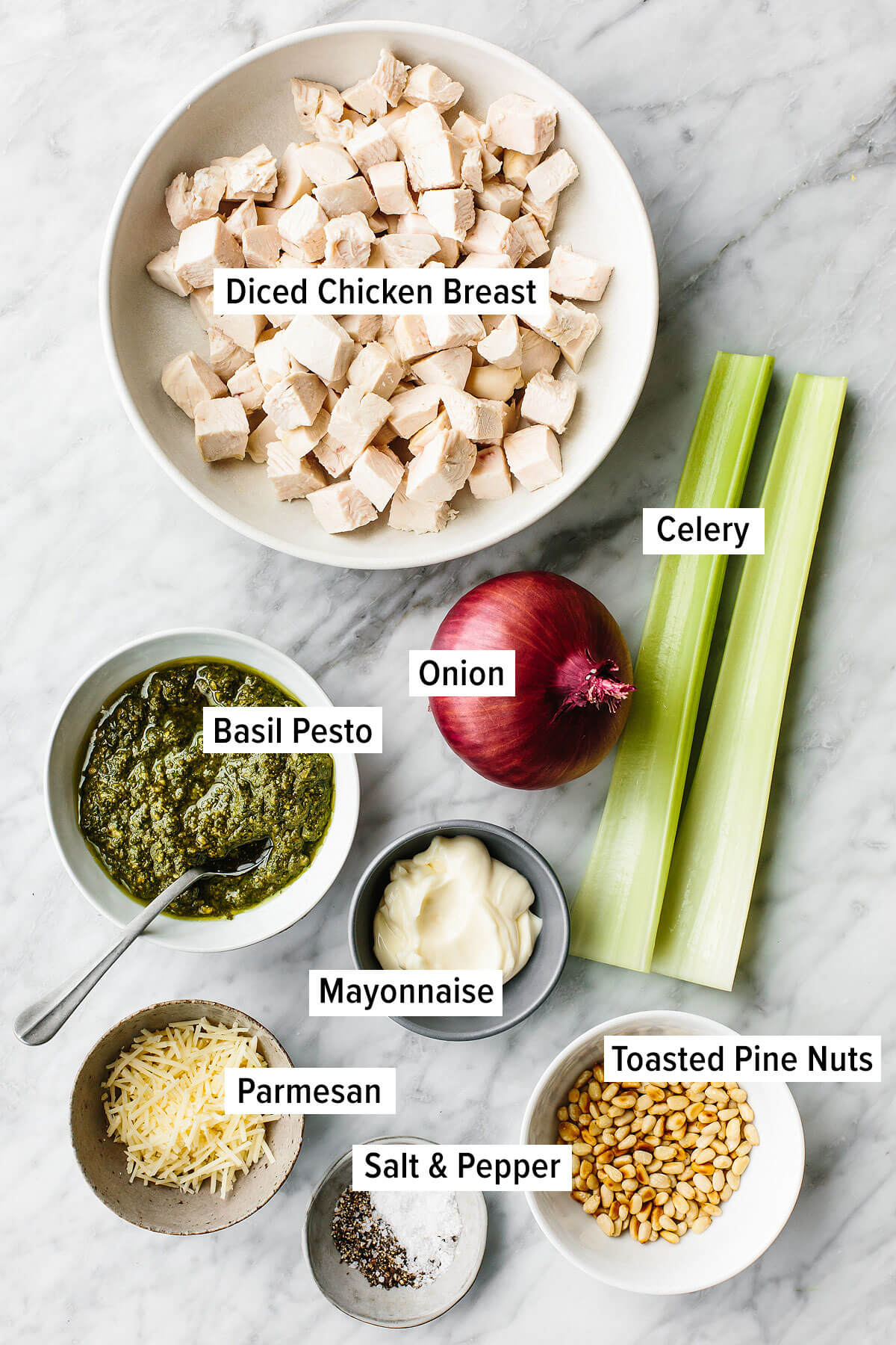 This pesto chicken salad is a fresh basil pesto spin on a classic that will undoubtedly be the summer salad of the season! Pesto chicken salad ingredients on a table