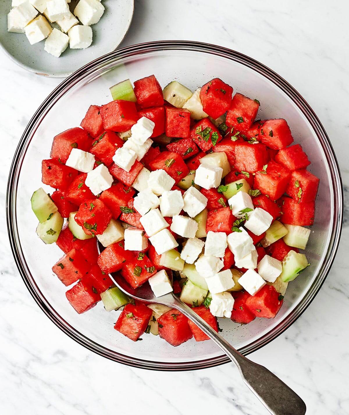 Making watermelon salad in a bowl.