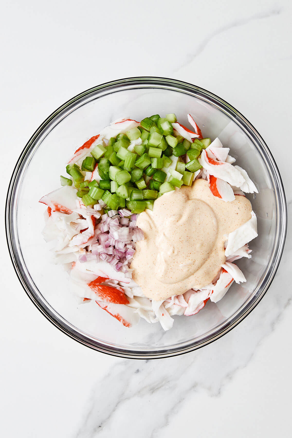 Mixing crab salad in a glass bowl
