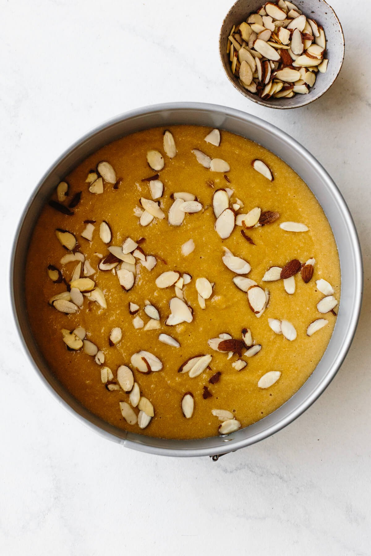 Raw almond cake batter in a cake pan