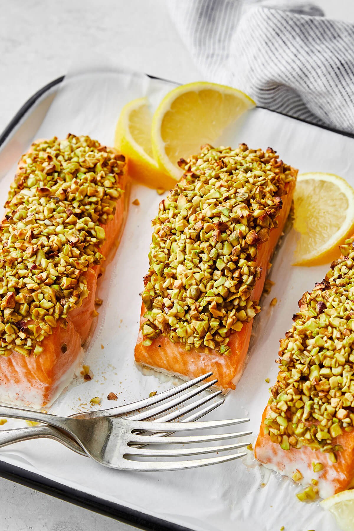 Pistachio crusted salmon next to forks
