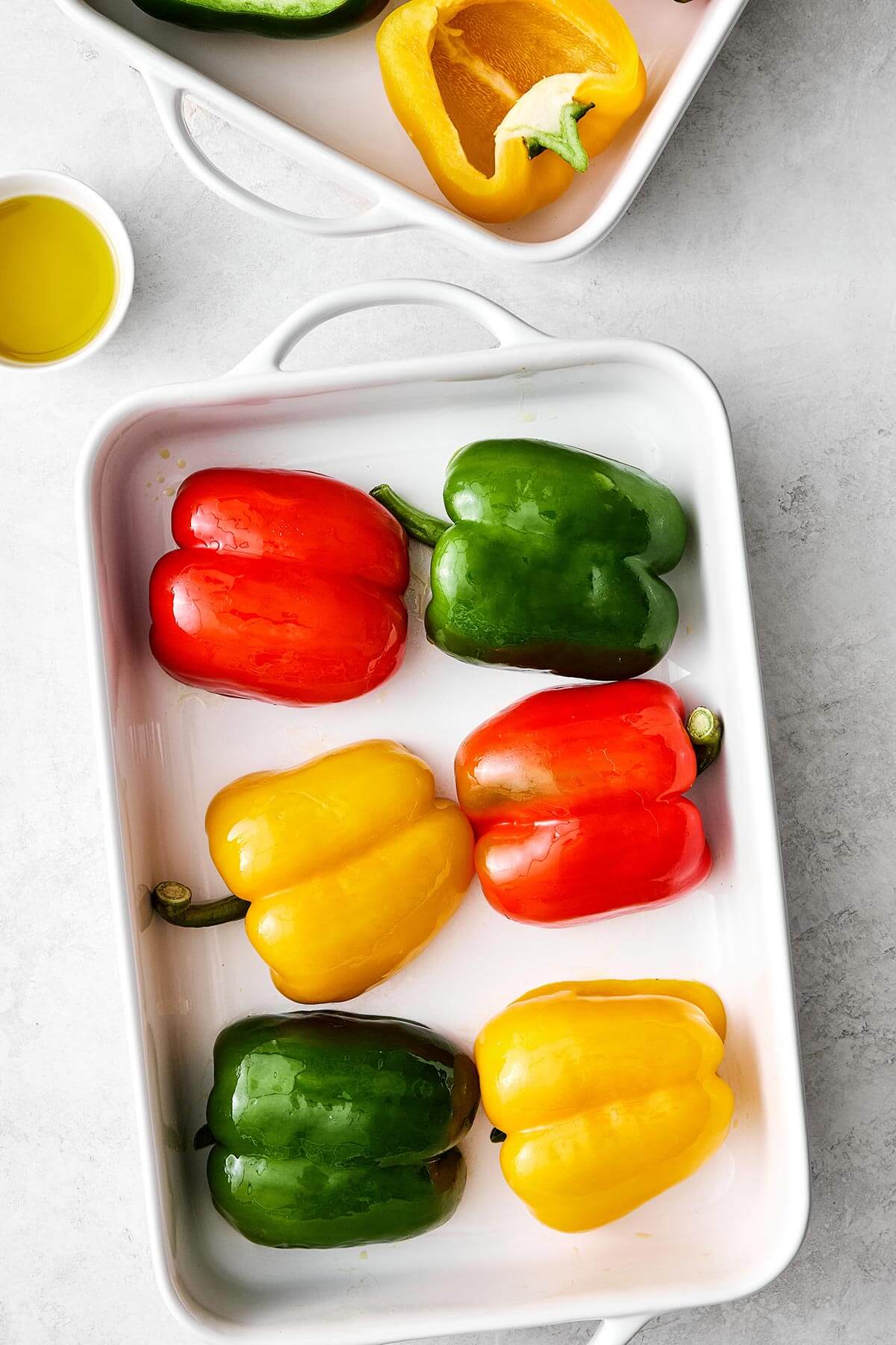 Stuffed peppers are always a family favorite weeknight dinner. This classic version is packed with the best filling — juicy ground beef, fluffy rice, and plenty of veggies seasoned with Italian flavors. Prepping bell peppers in a baking dish.