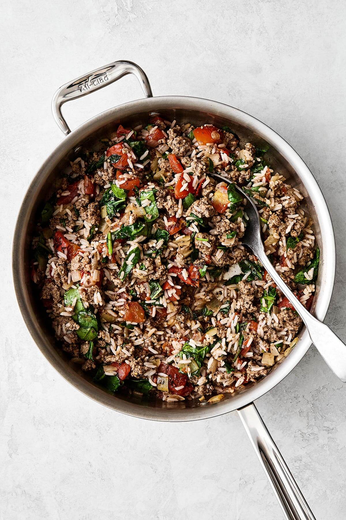 Stuffed peppers are always a family favorite weeknight dinner. This classic version is packed with the best filling — juicy ground beef, fluffy rice, and plenty of veggies seasoned with Italian flavors. Ground beef filling cooked in a pan.