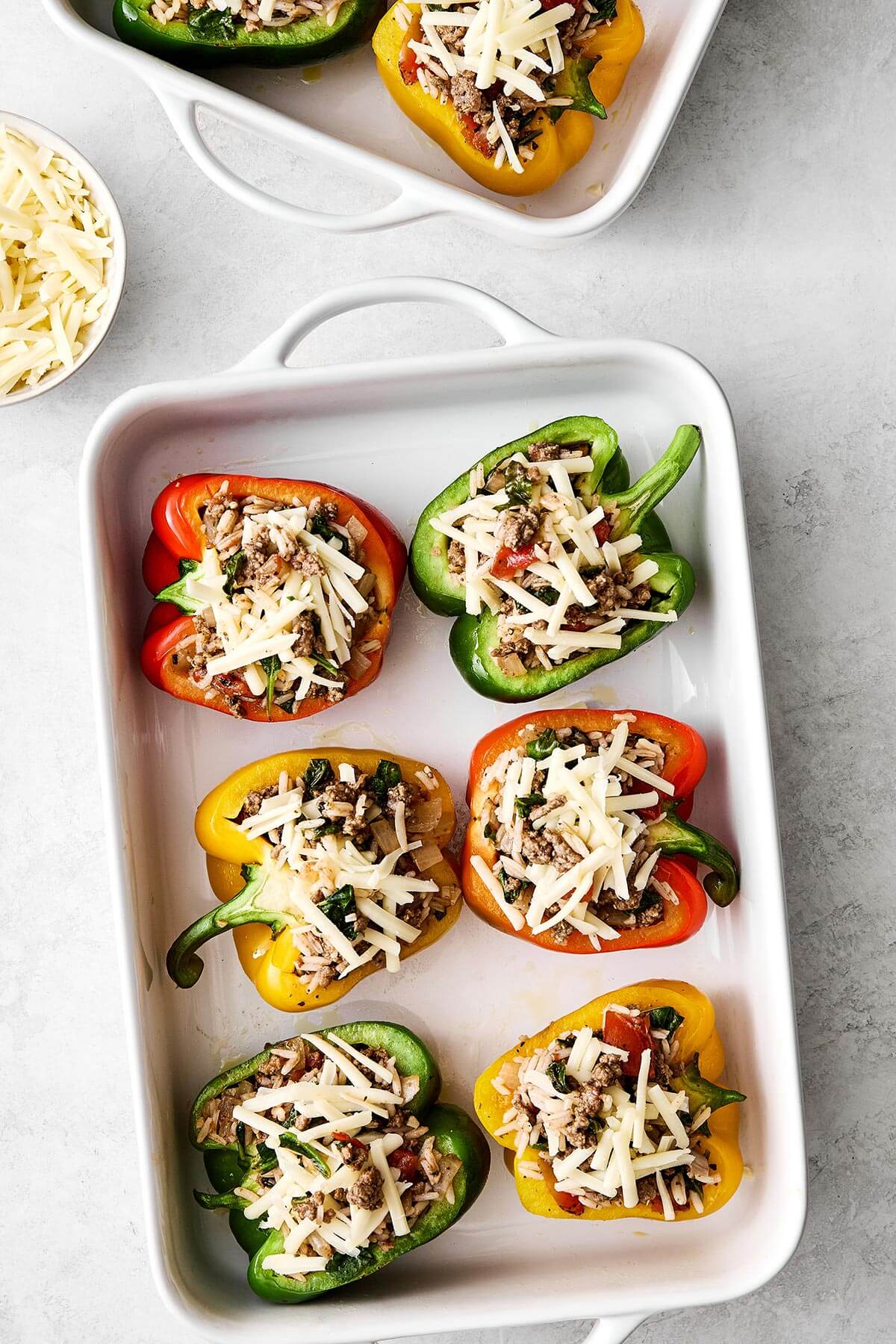 Stuffed peppers are always a family favorite weeknight dinner. This classic version is packed with the best filling — juicy ground beef, fluffy rice, and plenty of veggies seasoned with Italian flavors. Prepping stuffed peppers.