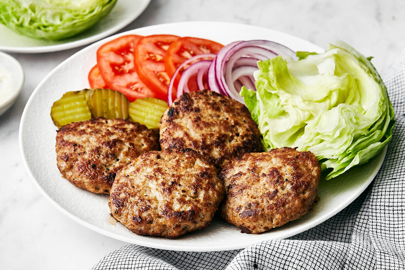 A white plate of turkey burger patties