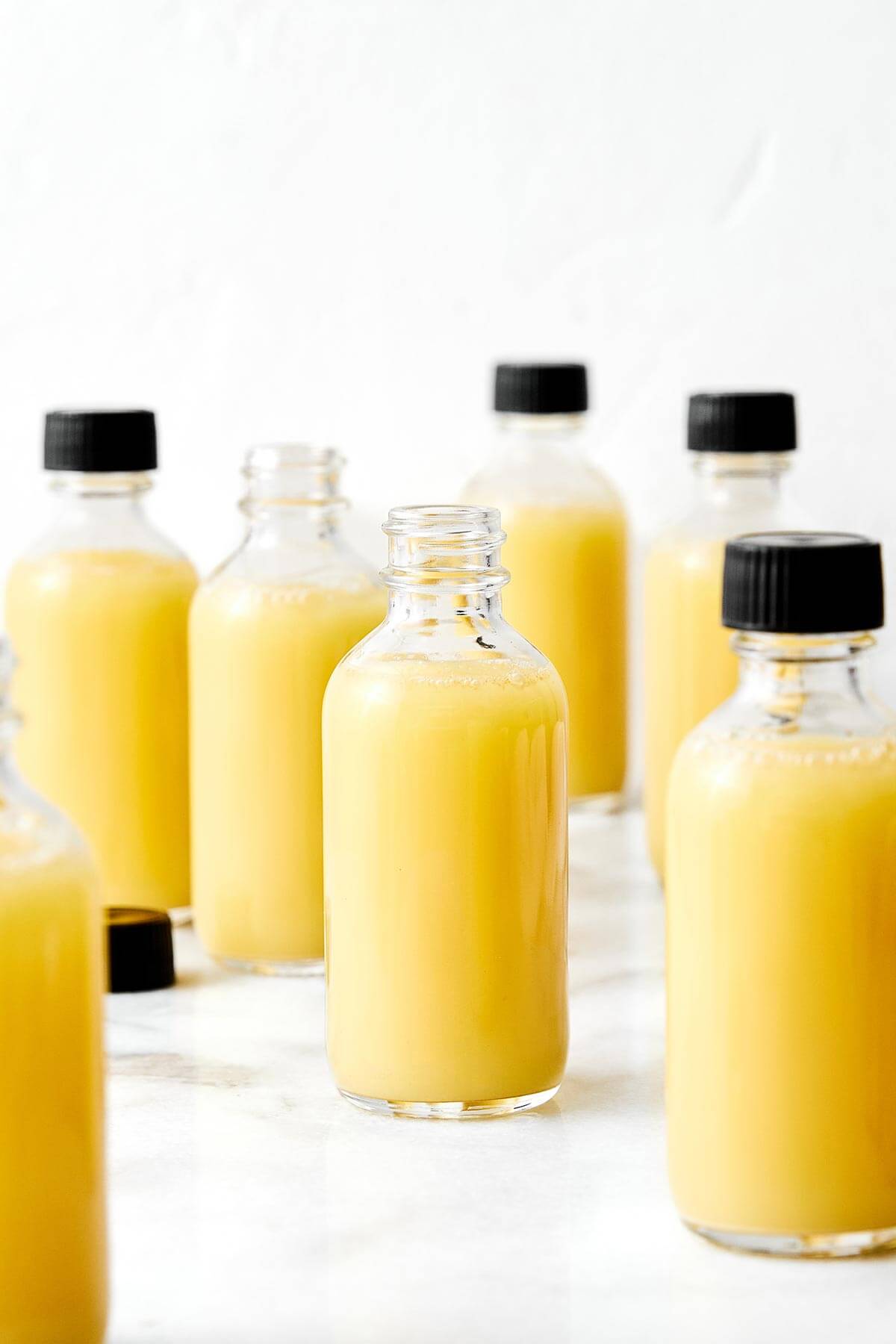 These homemade ginger shots are made easy in a blender, are the perfect anti-inflammatory and immunity booster packed with health benefits, and much more affordable than store-bought wellness shots! Bottles of ginger shots.
