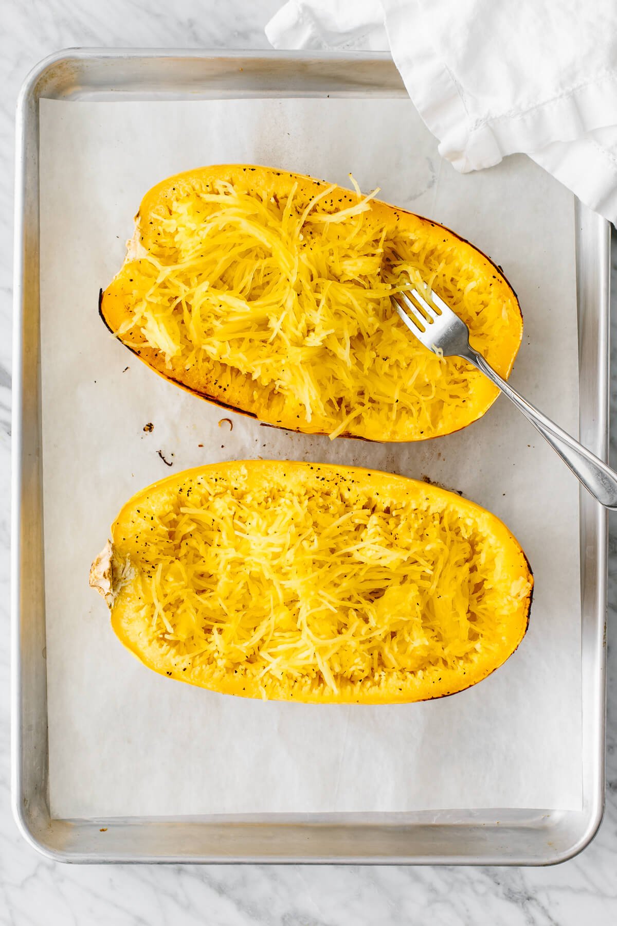 A fork in a spaghetti squash half.