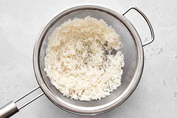 Washing rice in a colander for Mexican rice.