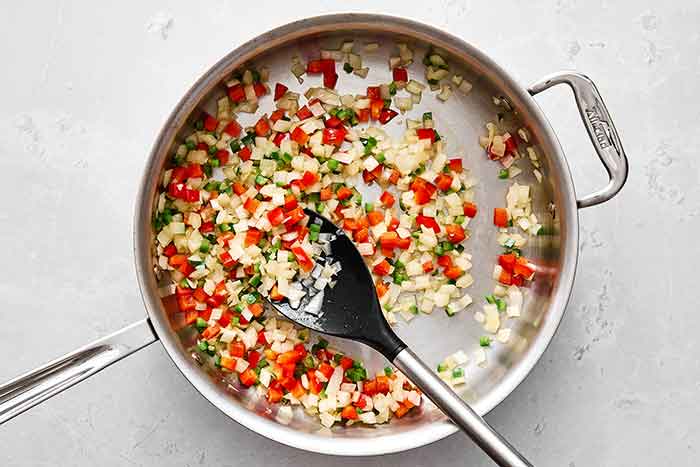 Cooking veggies in a pan for Mexican rice.