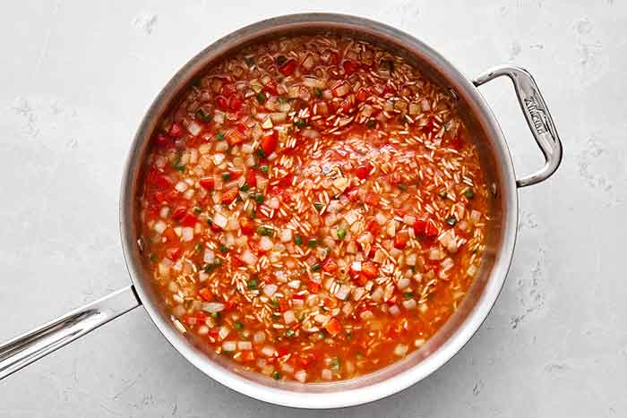 Simmering Mexican rice in a pan.