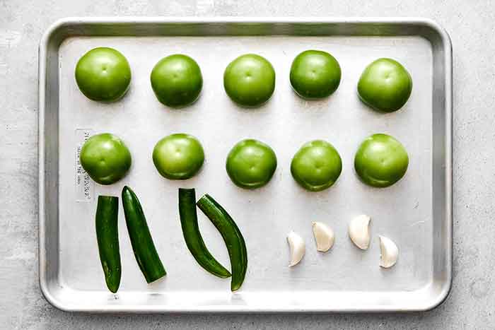 Roasting tomatillos and veggies to make roasted salsa verde.