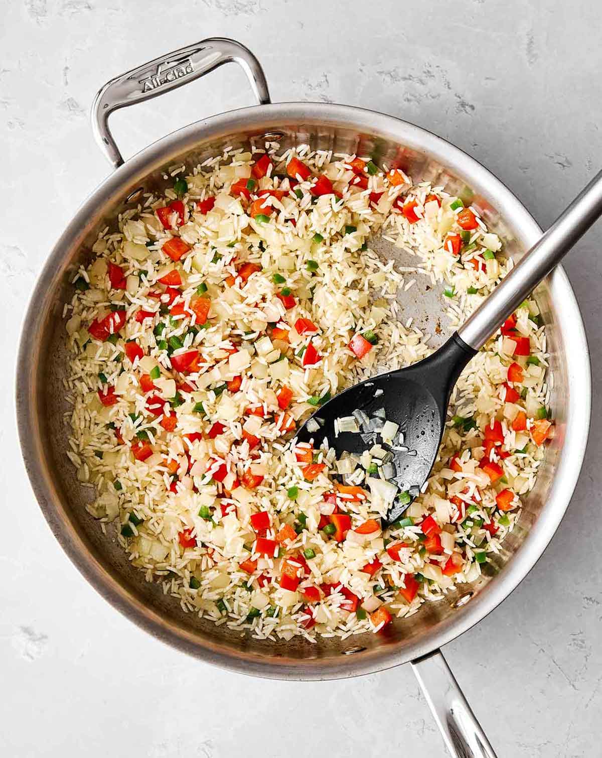 Cooking rice and veggies in a pan for Mexican rice.