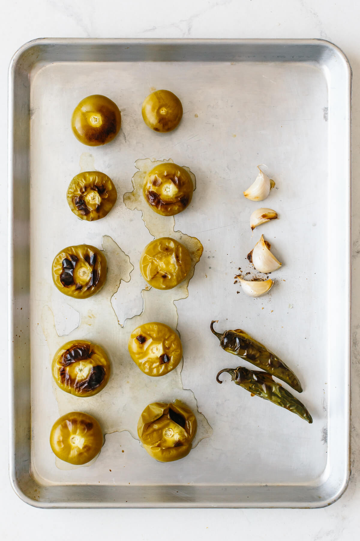 Add a spicy, flavorful kick to any Mexican dish with this homemade salsa verde (tomatillo salsa)! All you need is to roast, blend, and serve. Roasted ingredients on a sheet pan for salsa verde