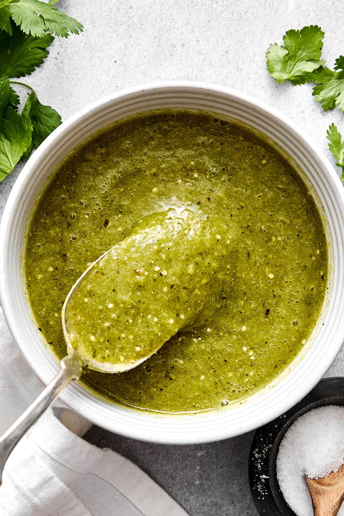 Salsa verde sauce in a bowl with a spoon.