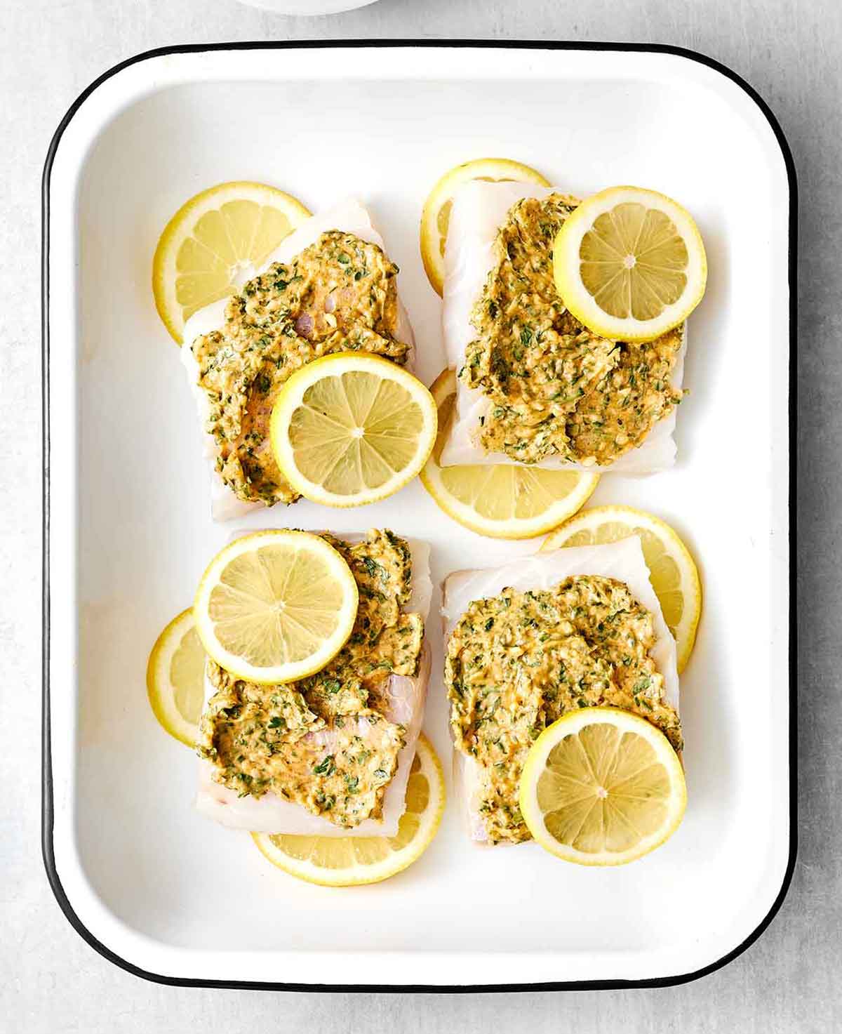 Step three of baked cod: add butter mixture and lemon on top.