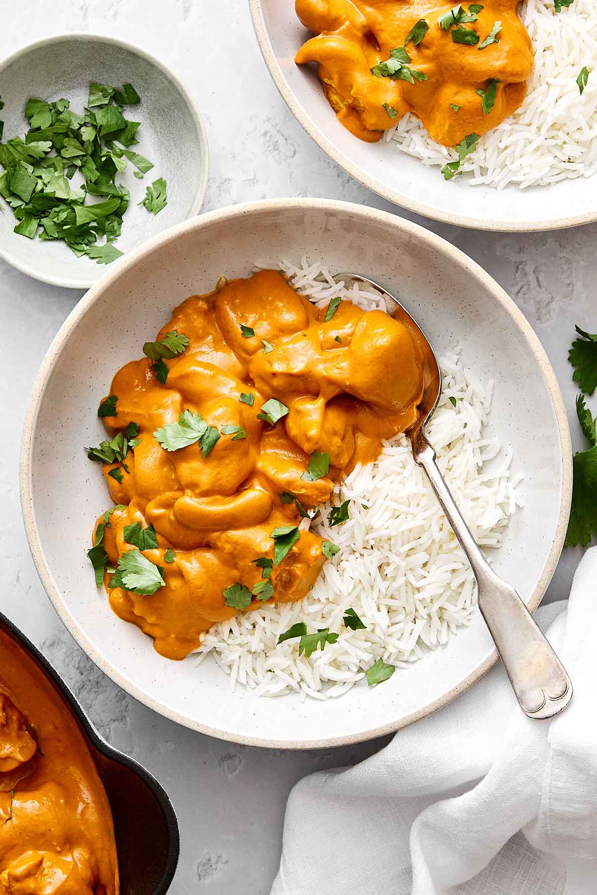 A bowl of Indian butter chicken with rice. 