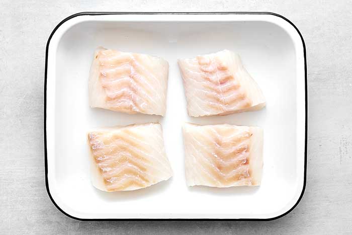 Step one of baked cod: pat the fillets dry.