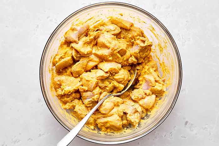 Step one: Marinating chicken in a yogurt spice blend for butter chicken.