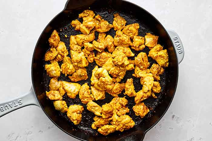 Step two: Cooking spiced chicken in a pan.