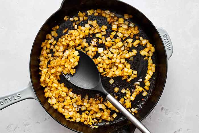 Cooking onions and spiced for butter chicken.