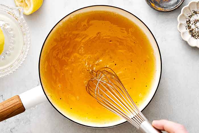 Whisking turmeric, lemon, black pepper, and water for turmeric tea.