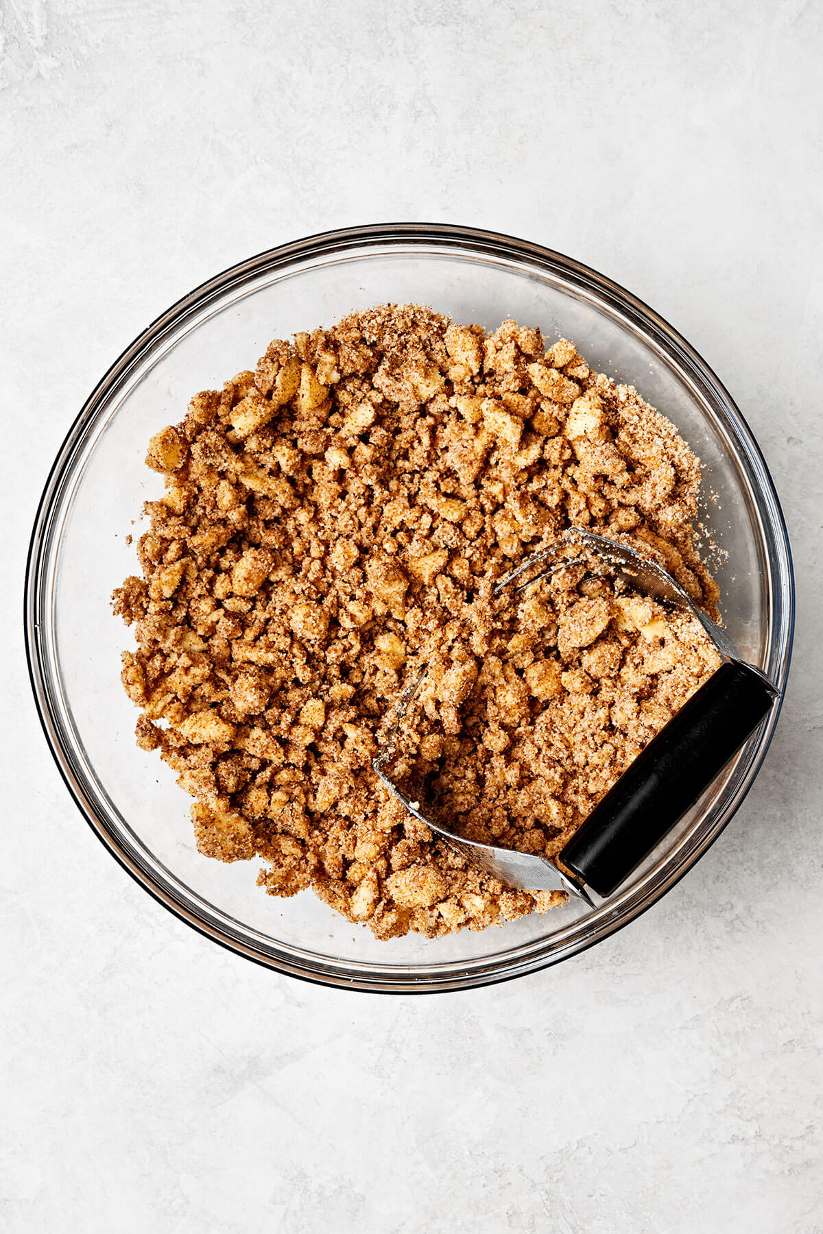 This apple crisp is the best holiday dessert with a sweet cinnamon apple filling and oat crumble topping — especially during Thanksgiving! Making an apple crisp oat topping in a bowl.