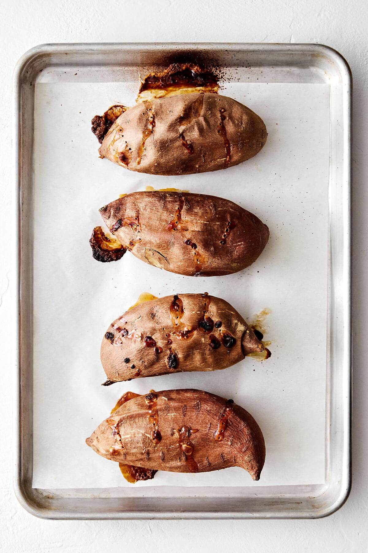 Baked sweet potatoes on a sheet pan.