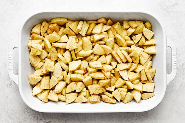 Apple crisp filling in a casserole dish.