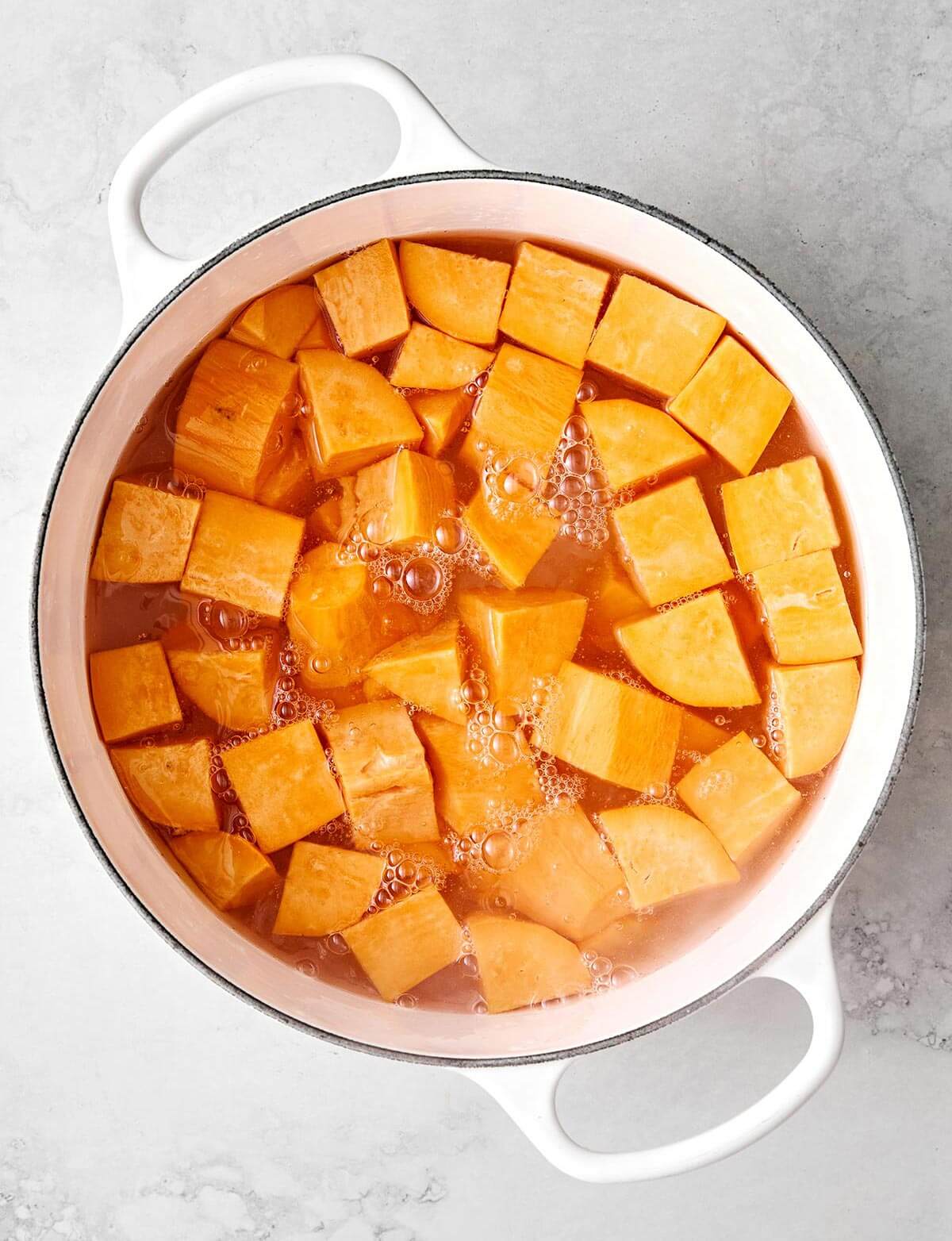 Boiling sweet potatoes in a pot.
