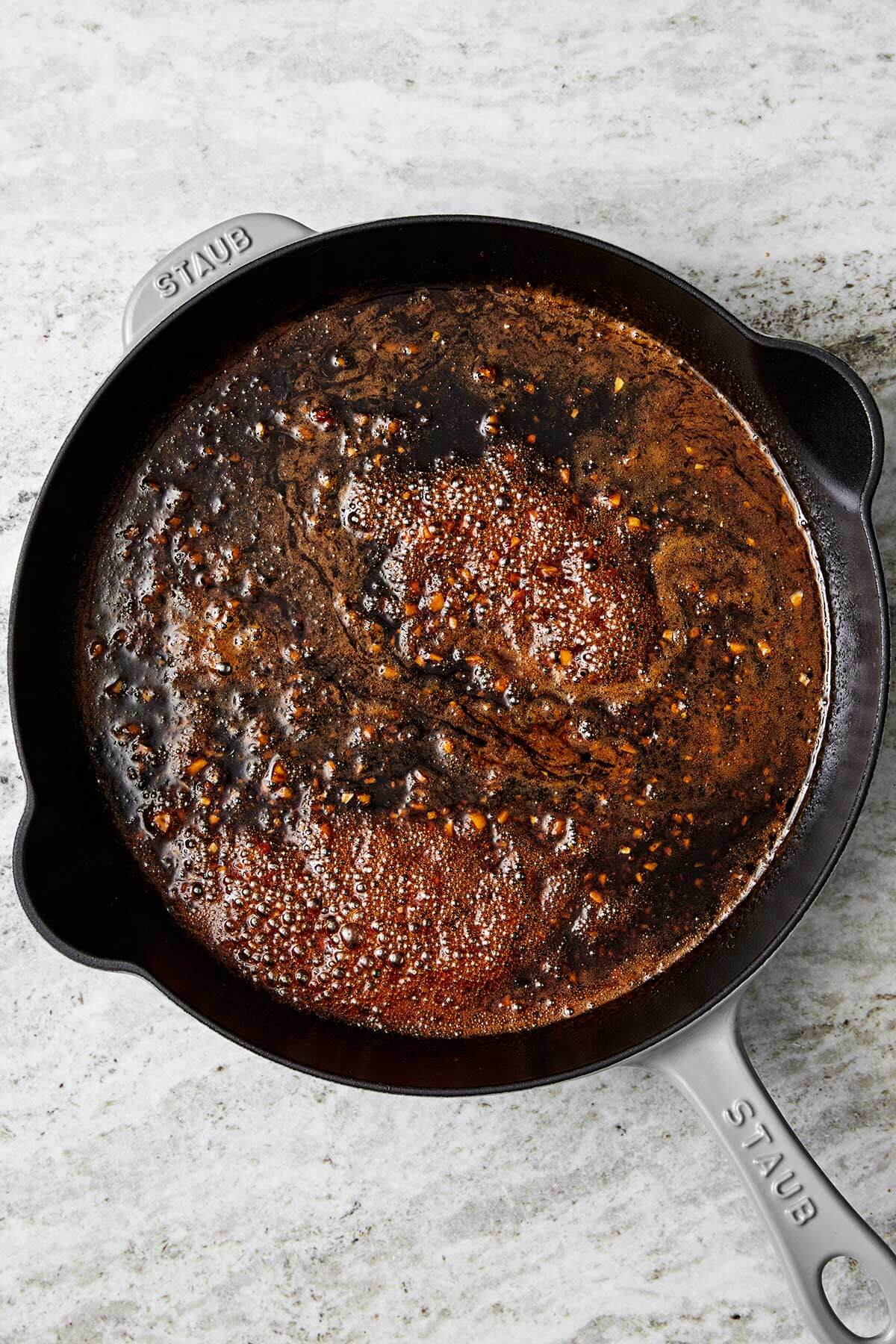 The juiciest pork tenderloin that's seasoned with a flavorful spice blend, seared to a golden crust, and baked with the best honey garlic sauce. Cooking sauce in a pan.