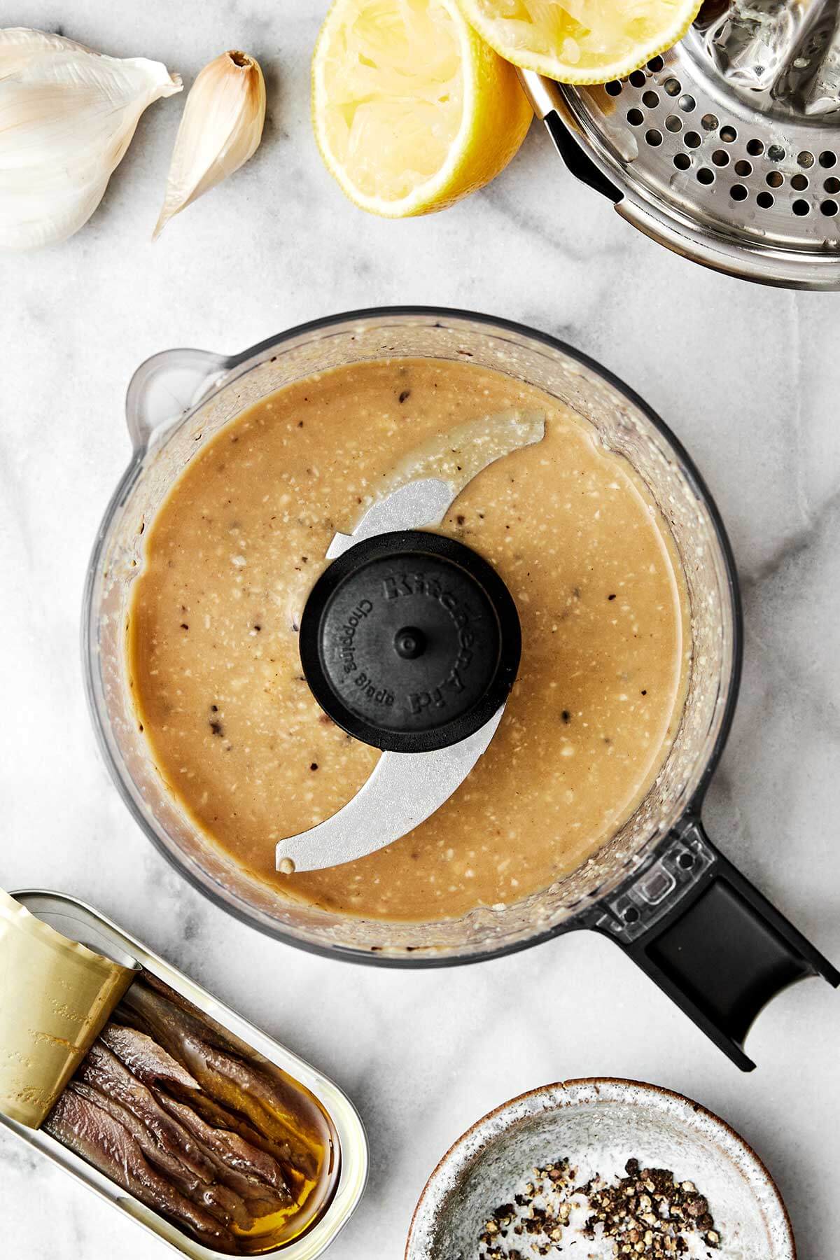 Blending Caesar dressing in a food processor.