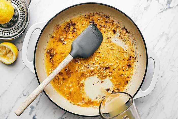Making garlic butter lemon sauce in a pan.