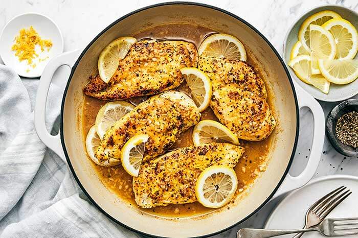 A white pan with lemon pepper chicken.