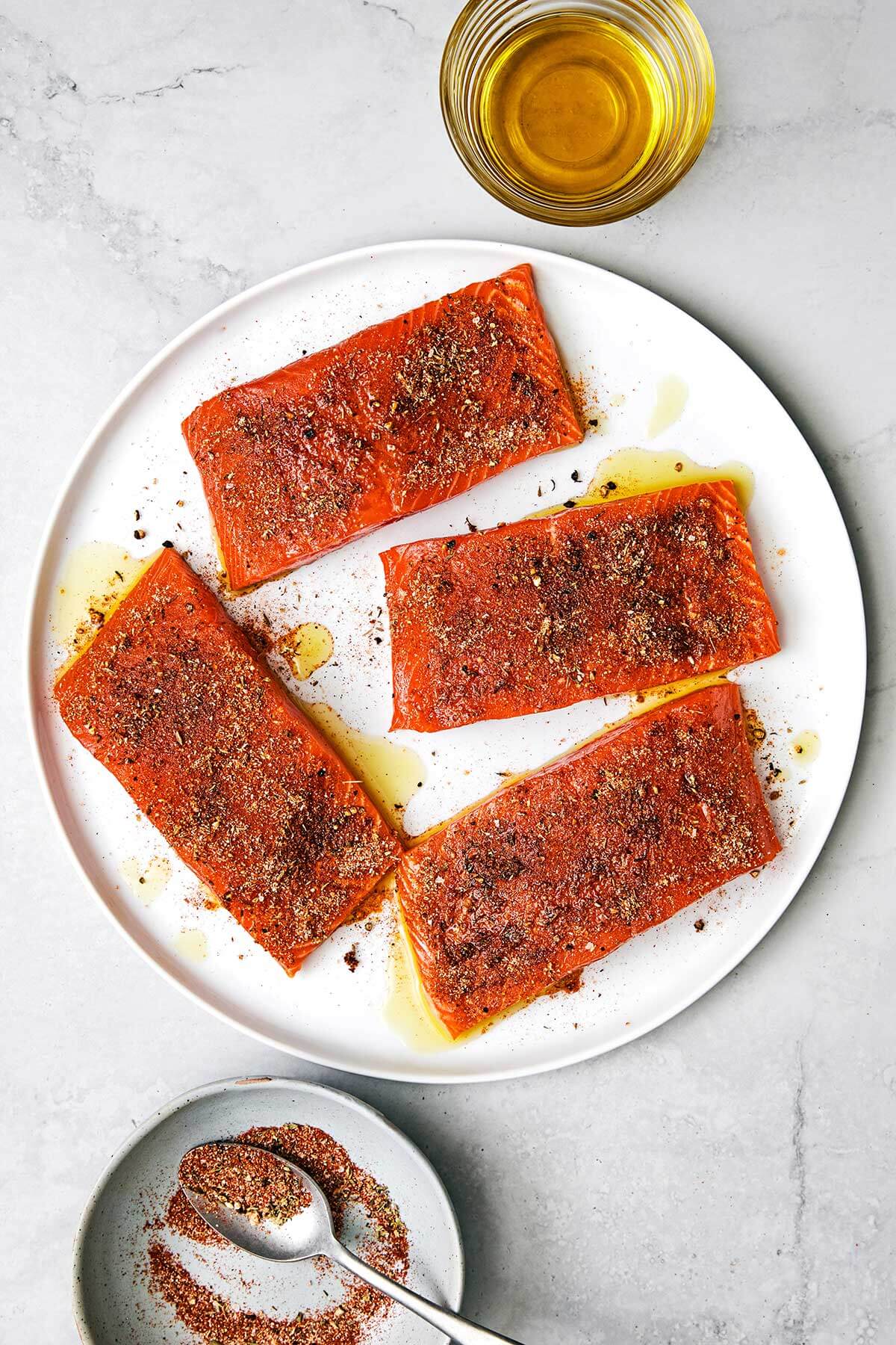 Adding blackened seasoning on salmon.