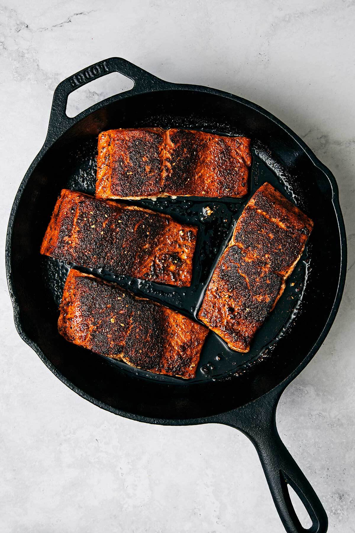 A skillet with blackened salmon.