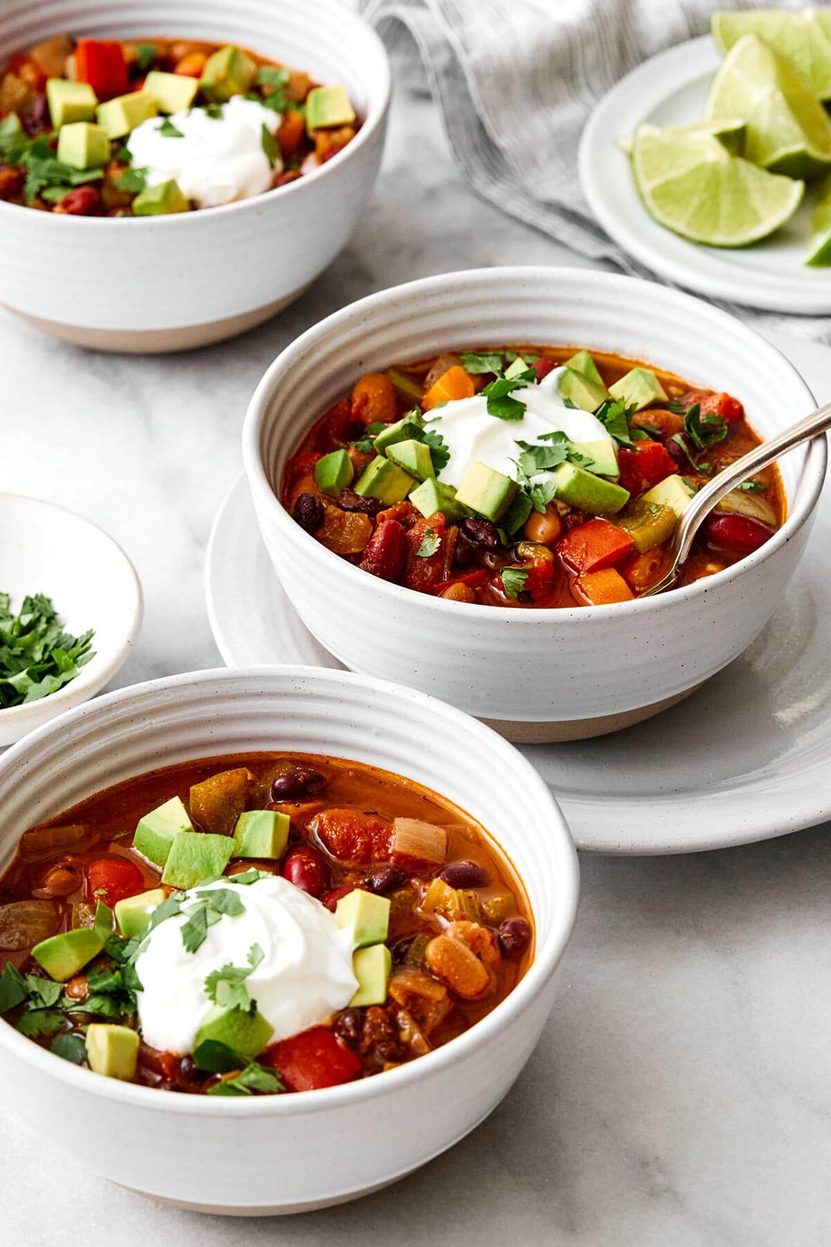 This vegetarian chili is a top-notch meatless dinner with layers of good-for-you vegetables, hearty beans, and warming spices! Bowls of vegetarian chili.