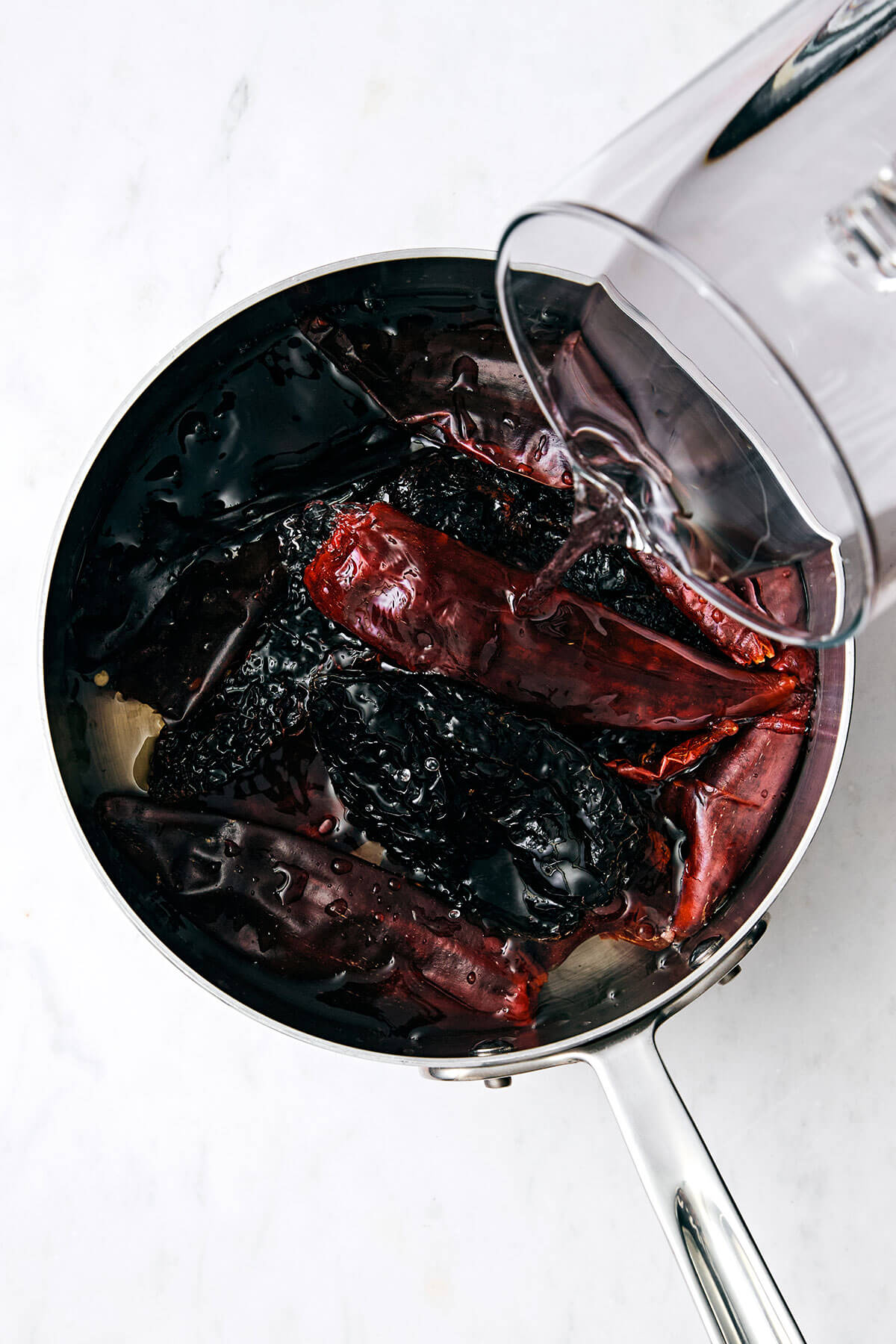 Mexican birria de res is a hearty slow-cooked stew with the utmost flavor and juicy, tender beef. Serve it as is or make birria tacos! Boiling Mexican chiles in a pot.