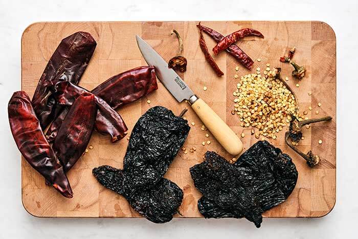 Deseeding chiles on a wooden board.