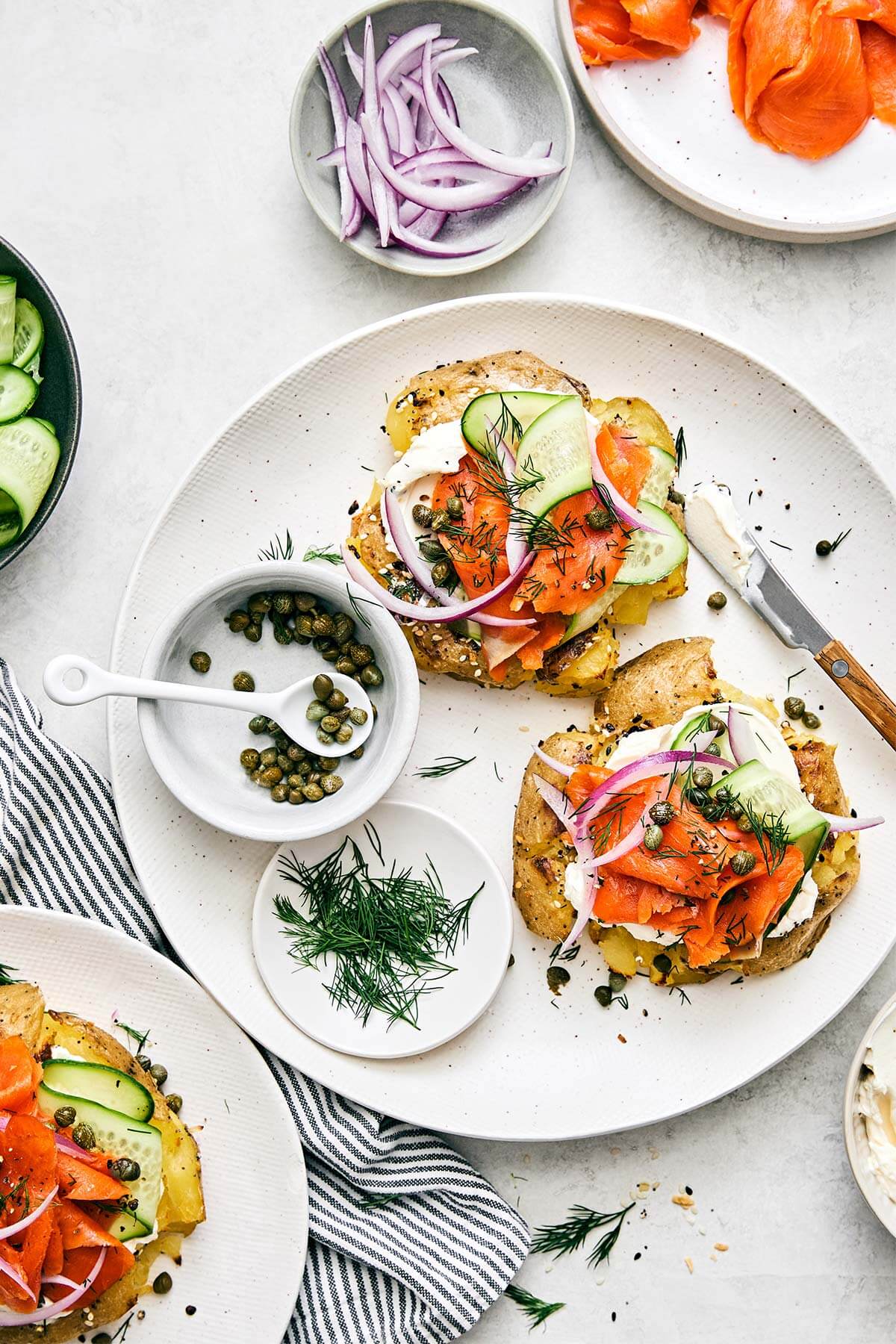 Smashed potatoes lox bagel on a plate.