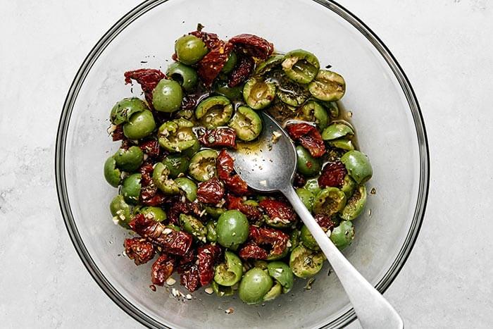 Olives and sun-dried tomatoes in a bowl.