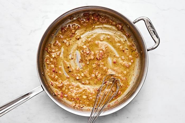 Making a bacon vinaigrette in a pan.