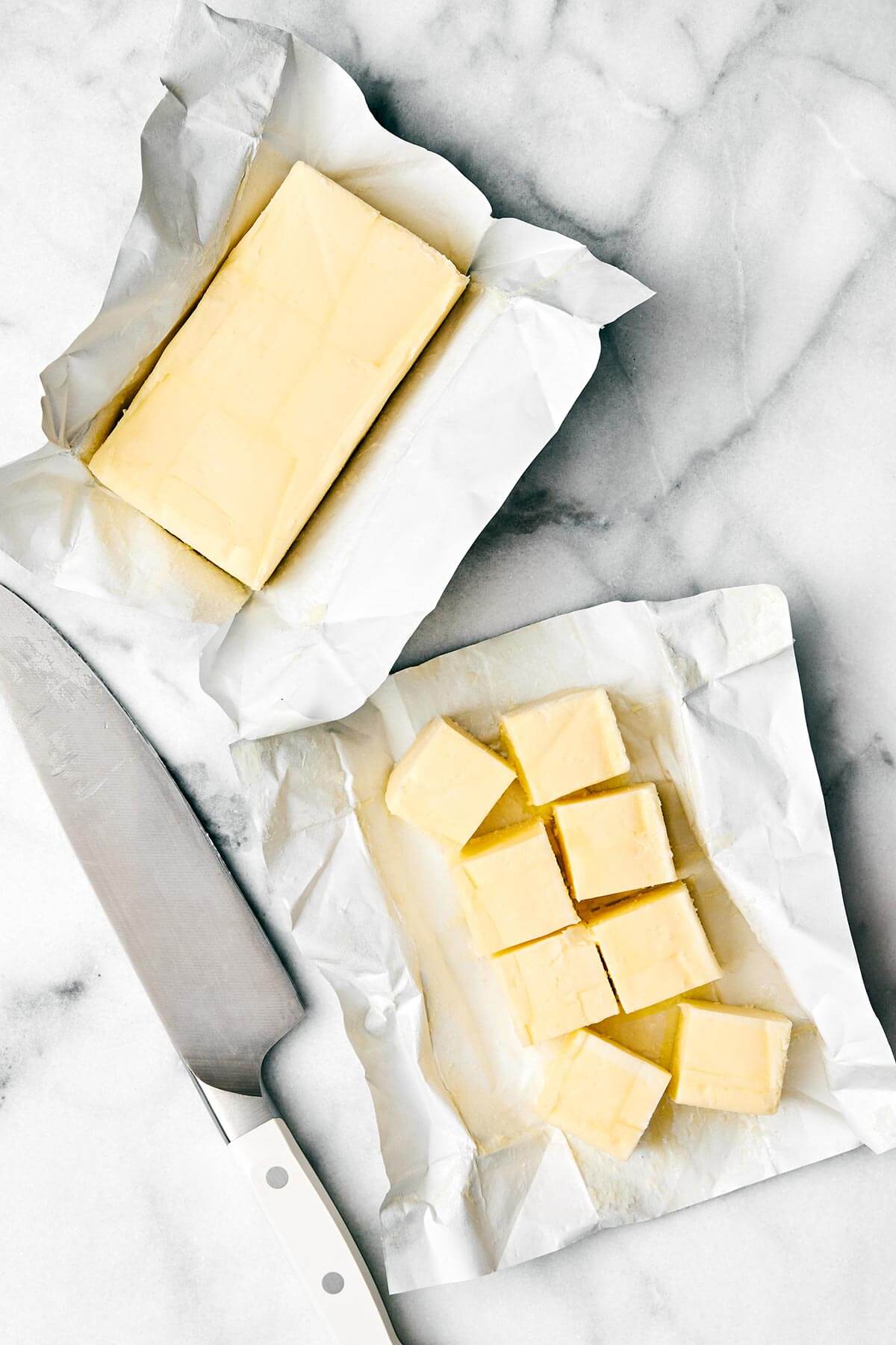 Homemade ghee (clarified butter) is incredibly easy to make, much cheaper than store-bought versions, and is perfect for those who are dairy-sensitive. Sliced butter on a table.