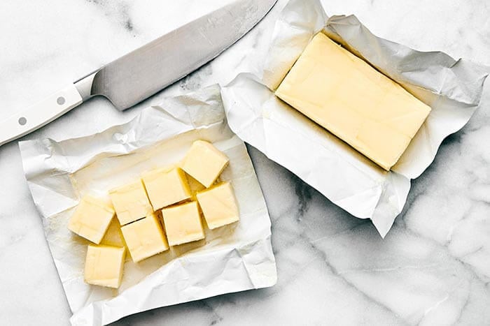 Sliced butter next to a knife.