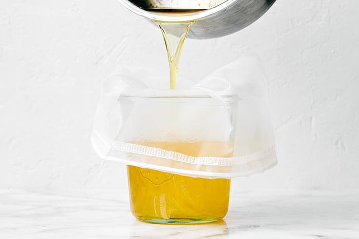 Straining butter through a fine mesh sieve.