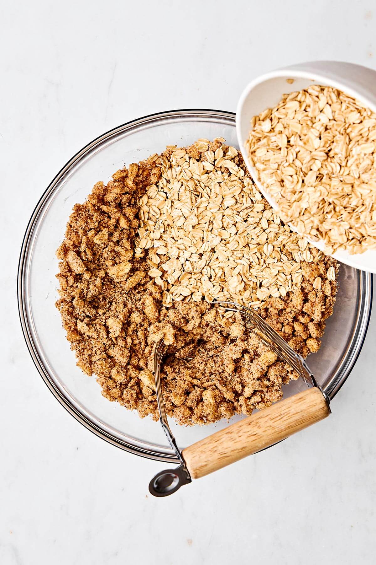 This peach crisp dessert with a crumble oatmeal topping is the best way to celebrate summer peach season! Plus, it's completely gluten-free. Making an oatmeal crumble in a bowl.